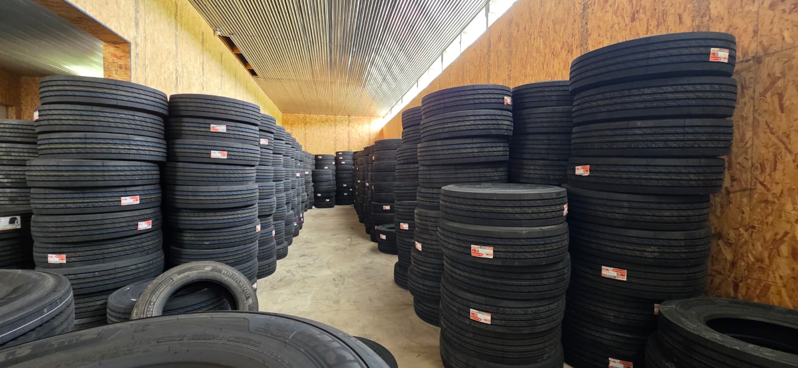 Industrial warehouse heavily stocked with rows of premium commercial tires